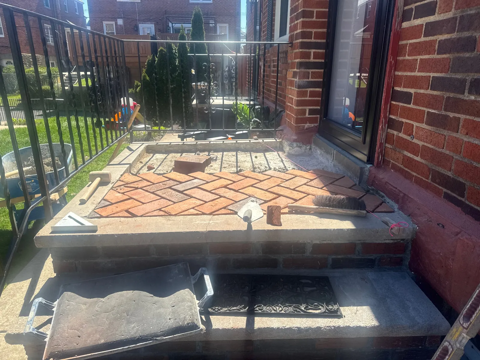 Before: Stoop rebuilt with a herringbone brick inlay inside a concrete border